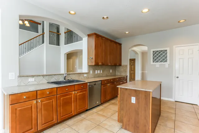 a large kitchen with stainless steel appliances granite countertop a sink and a stove