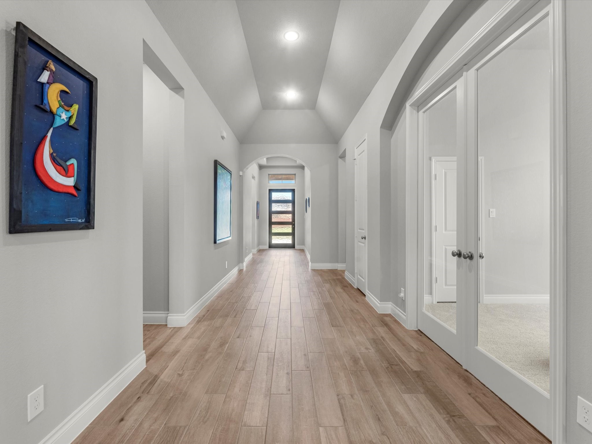 10135 Napier Drive Rosharon, TX 77583 - Photo 16 of 36 As we move toward the front of the home, you’re greeted by a beautiful view of the oversized corridor with high ceilings. To the right, a spacious flex room offers options for a media room, home office, or formal dining area, while to the left is a full bath and one of the larger secondary bedrooms.