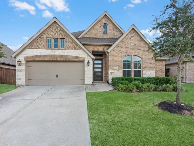 a front view of a house with a yard and garage