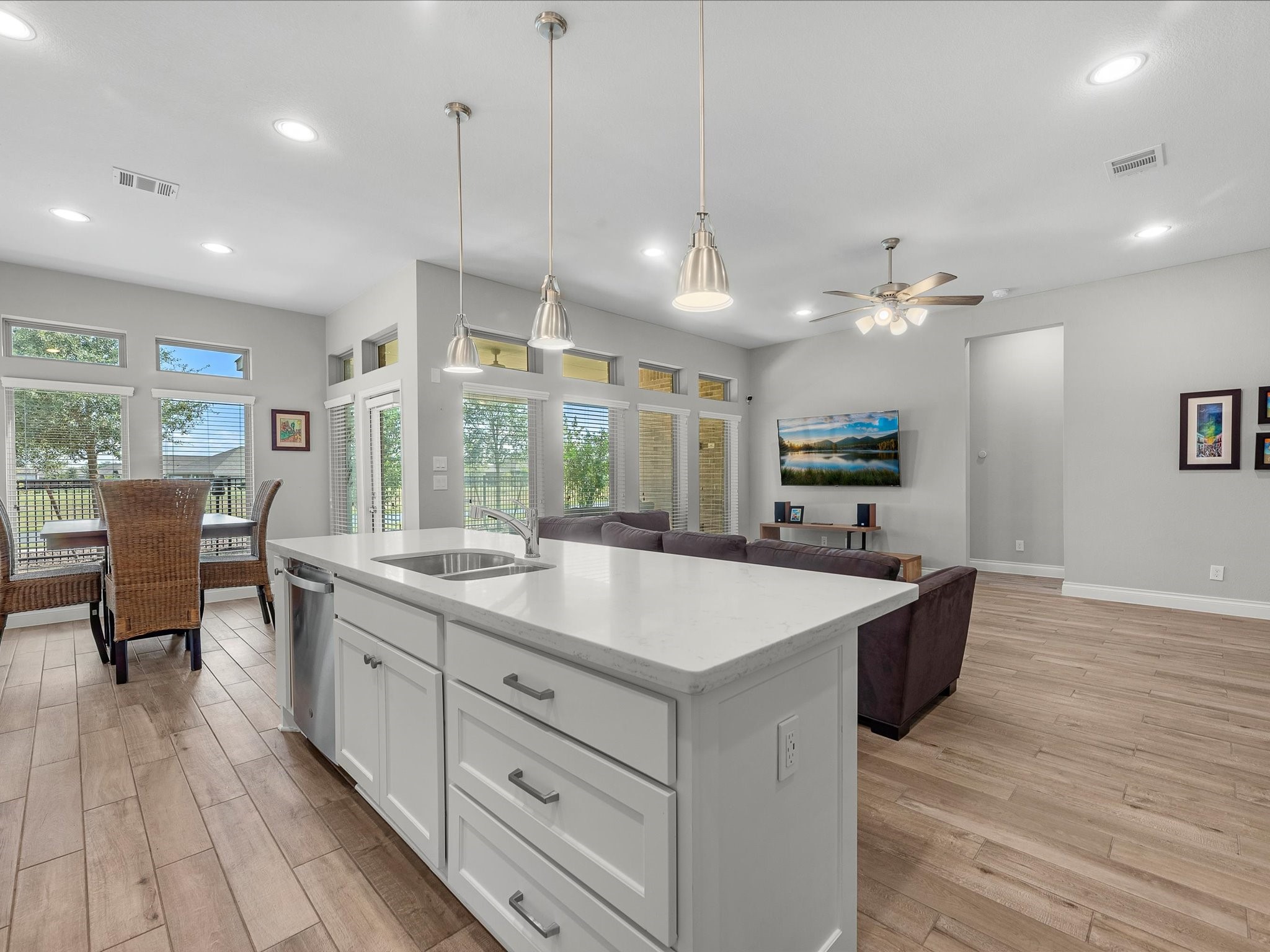 10135 Napier Drive Rosharon, TX 77583 - Photo 8 of 36 View from the kitchen overlooking the open living room and breakfast nook, with large windows framing the covered patio and peaceful backyard beyond.