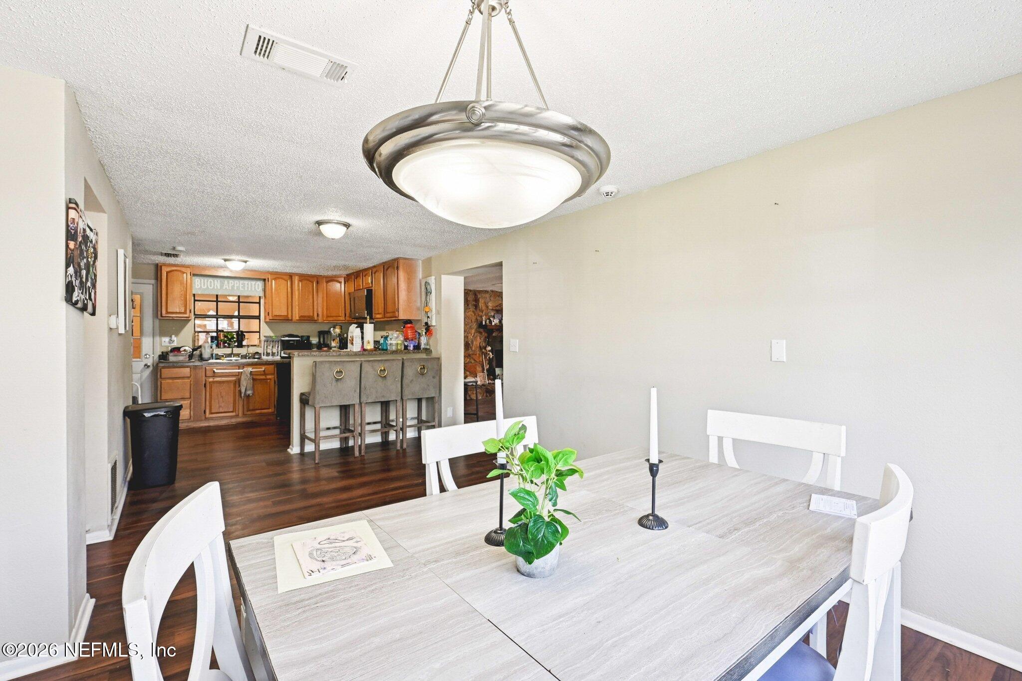 2914 Carleon Road Jacksonville, FL 32218 - Photo 15 of 39 a dining room with furniture and a chandelier