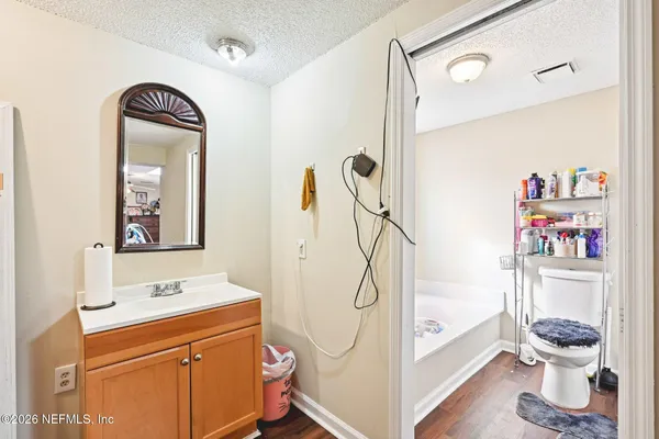 a bathroom with a granite countertop sink mirror vanity and toilet