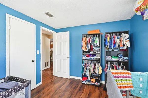 a view of kids room with toys and wooden floor