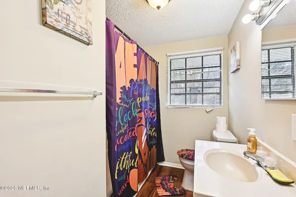 a bathroom with a sink toilet and window