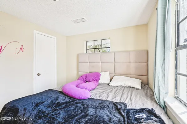 a bedroom with a bed and a potted plant