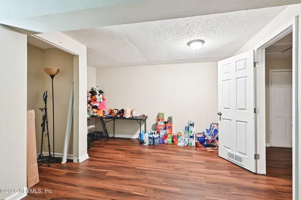 a view of a hallway with wooden floor and furniture