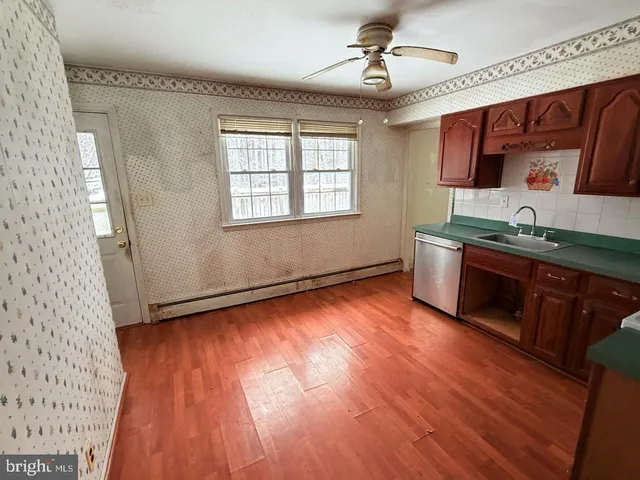 a view of a kitchen with stainless steel appliances granite countertop a sink and wooden floor