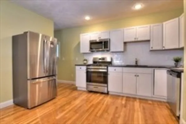 a kitchen with granite countertop a refrigerator stove and microwave