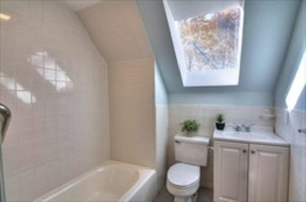 14 Beltran Street, Unit 2 Malden, MA 02148 - Photo 4 of 12 a white toilet sitting next to a bathroom sink and tub