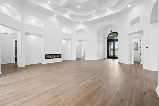 a kitchen that has a lot of white cabinets and wooden floor