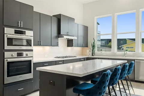 a kitchen with granite countertop a table chairs microwave and sink