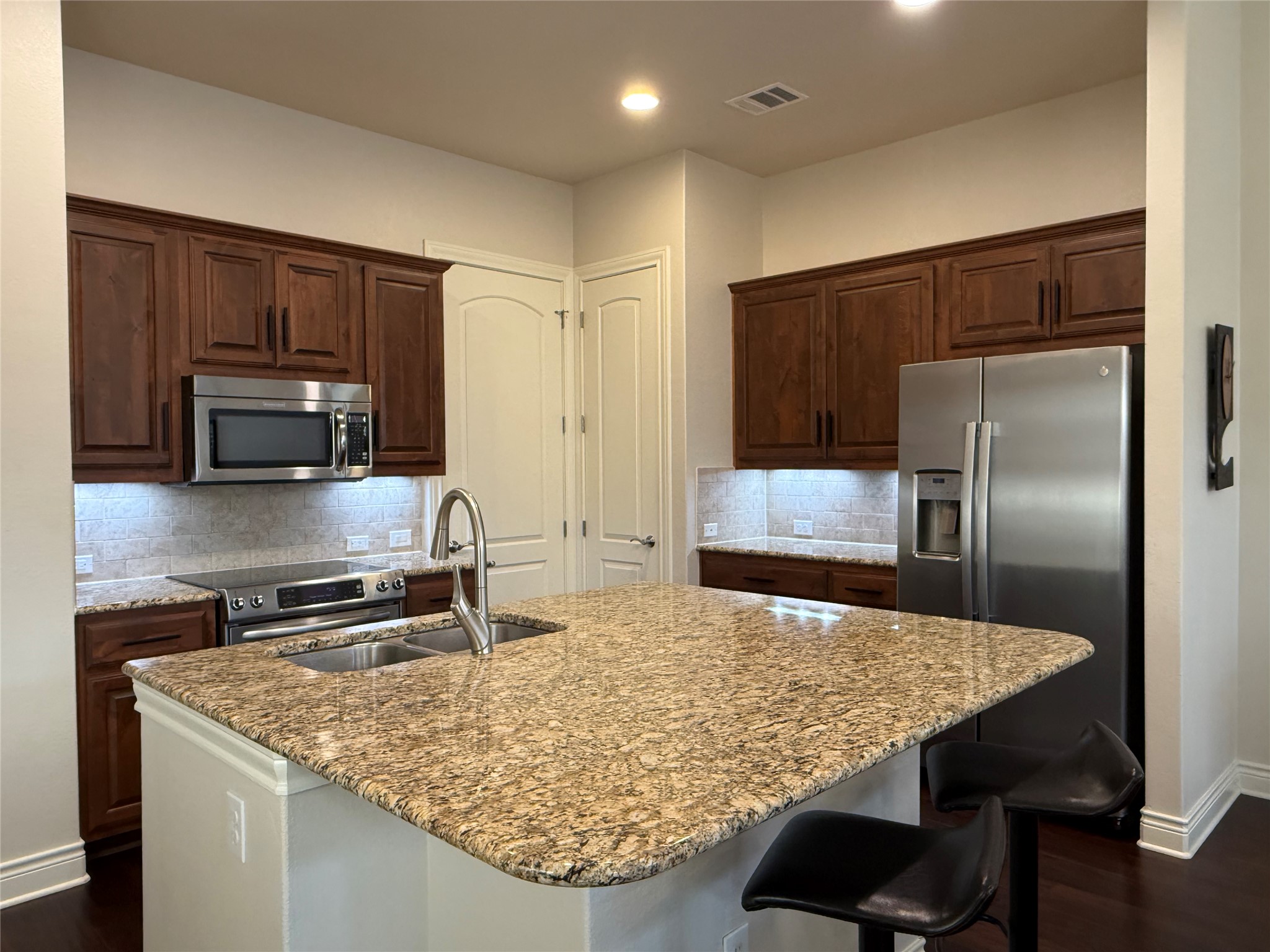 108-2 Rivalto Circle, Unit C3 Lakeway, TX 78734 - Photo 11 of 35 a kitchen with kitchen island granite countertop a sink refrigerator and microwave