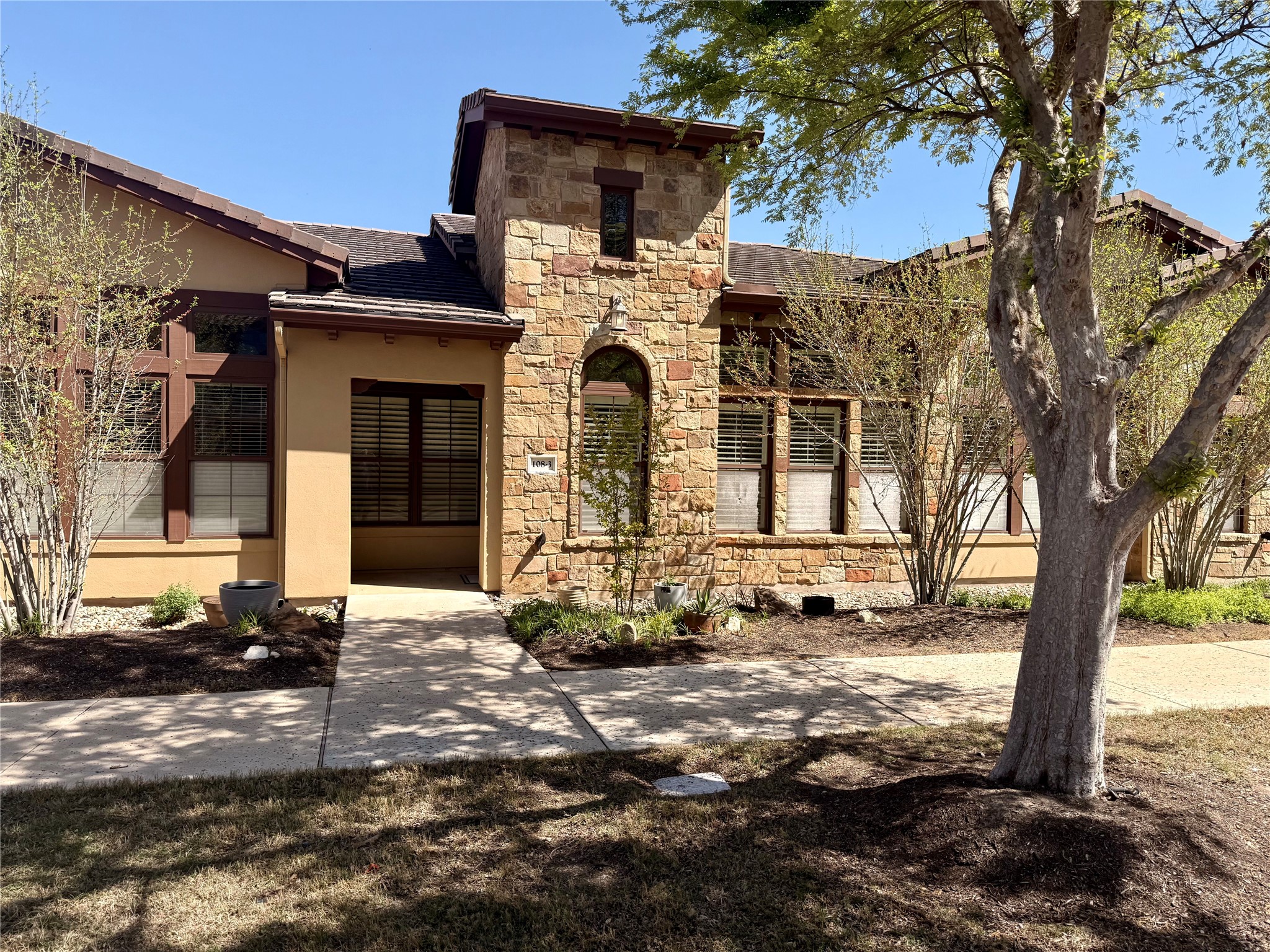 108-2 Rivalto Circle, Unit C3 Lakeway, TX 78734 - Photo 4 of 35 a front view of a house with a tree