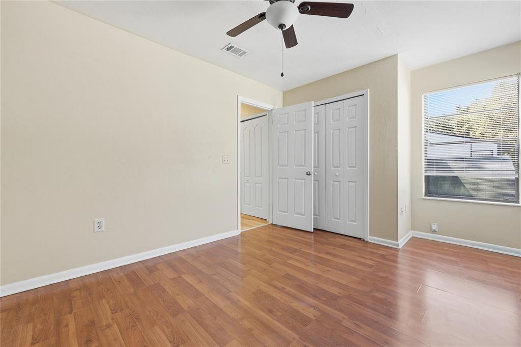 4427 Southwest 21st Lane Gainesville, FL 32607 - Photo 21 of 36 an empty room with wooden floor chandelier fan and windows