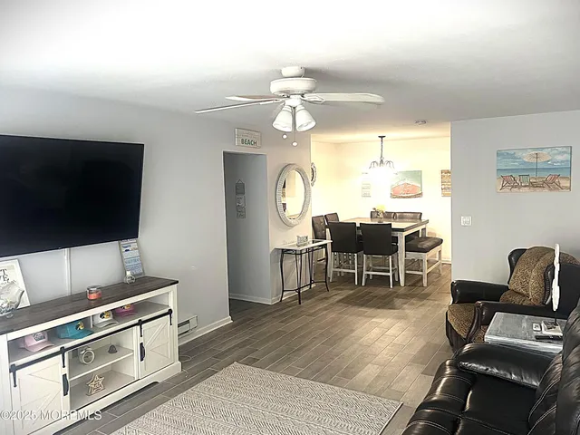 a living room with furniture a flat screen tv and kitchen view
