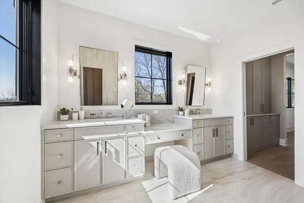 a bathroom with a granite countertop double vanity sink and a mirror