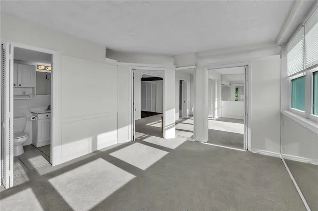 an empty room with closet and ceiling fan