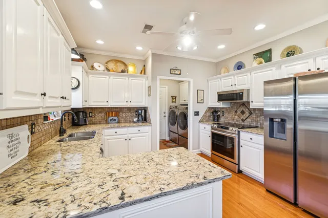 a kitchen with granite countertop white cabinets and a sink