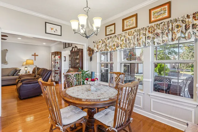 a view of a dining room with furniture a chandelier and wooden floor