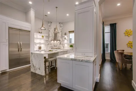 a kitchen with kitchen island granite countertop a sink and refrigerator