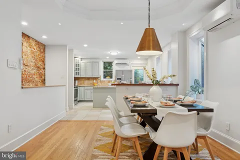 a dining room with furniture a window and wooden floor