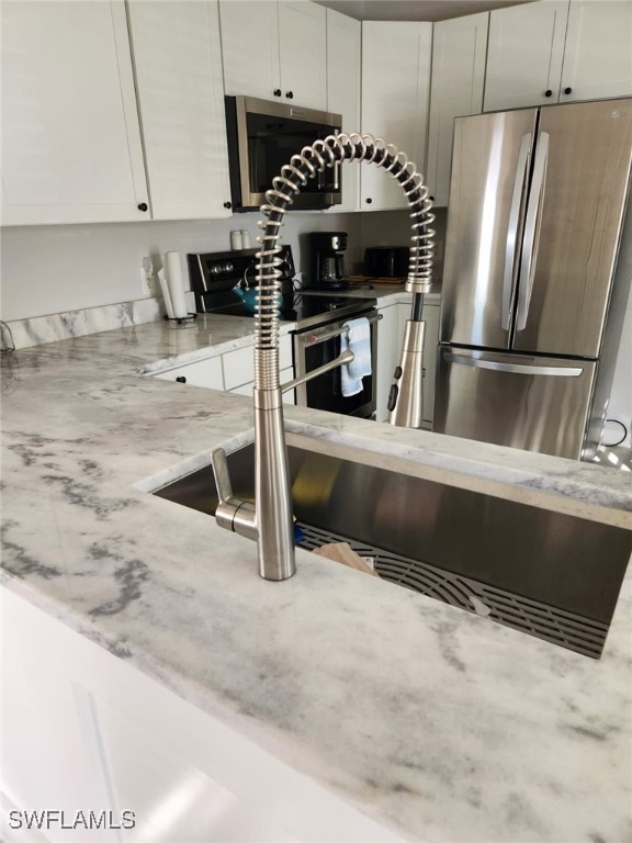 10823 Ani Circle Estero, FL 33928 - Photo 13 of 31 a kitchen with stainless steel appliances kitchen island granite countertop a refrigerator a stove and a sink