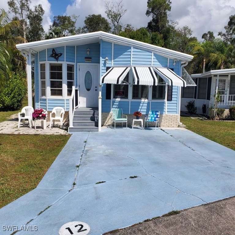 10823 Ani Circle Estero, FL 33928 - Photo 3 of 31 a patio with a table and chairs under an umbrella