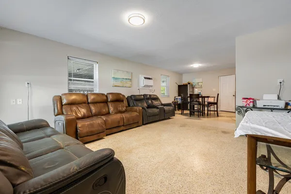a living room with furniture kitchen view and a flat screen tv