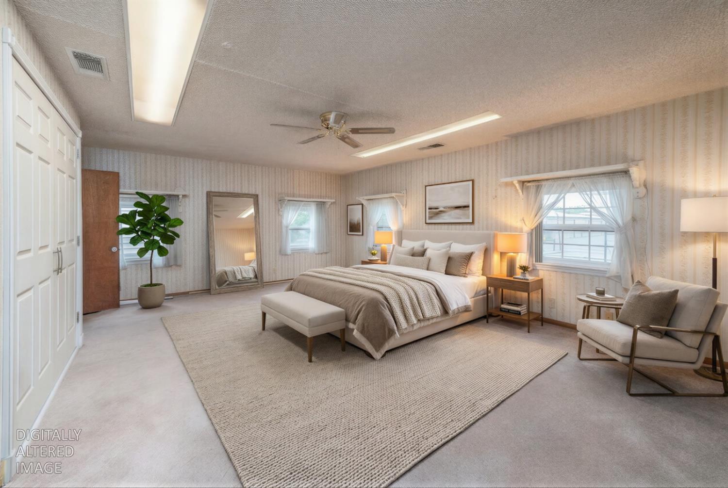 a bedroom with a bed couch and windows