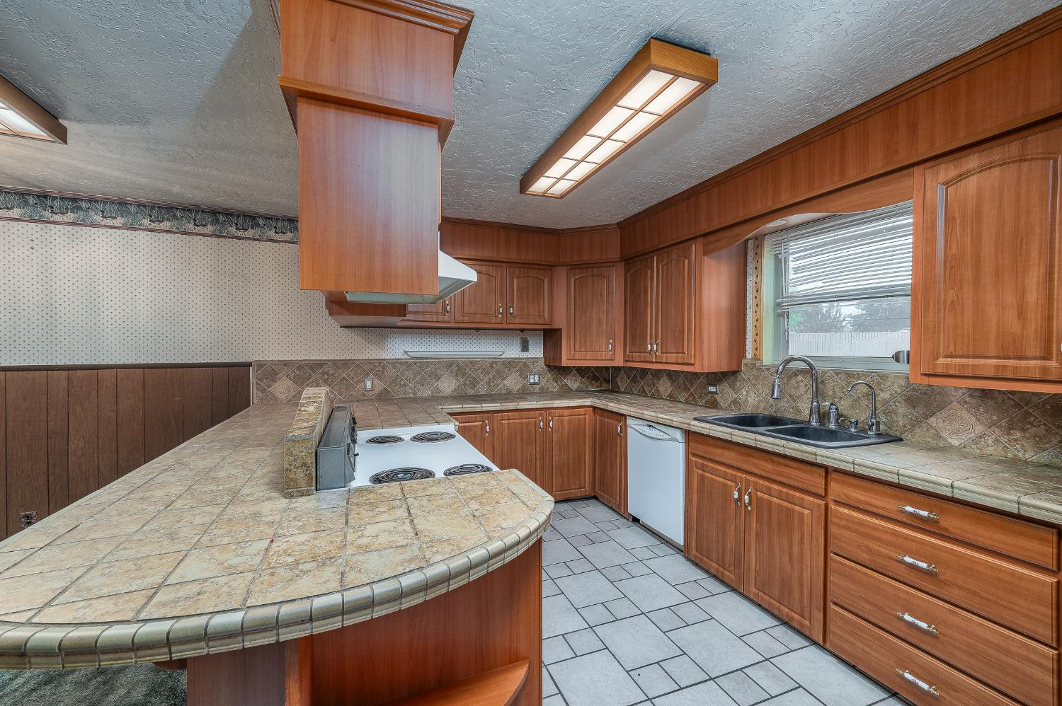 13230 4th Street Hickman, CA 95323 - Photo 35 of 54 a kitchen with granite countertop a sink a stove and cabinets