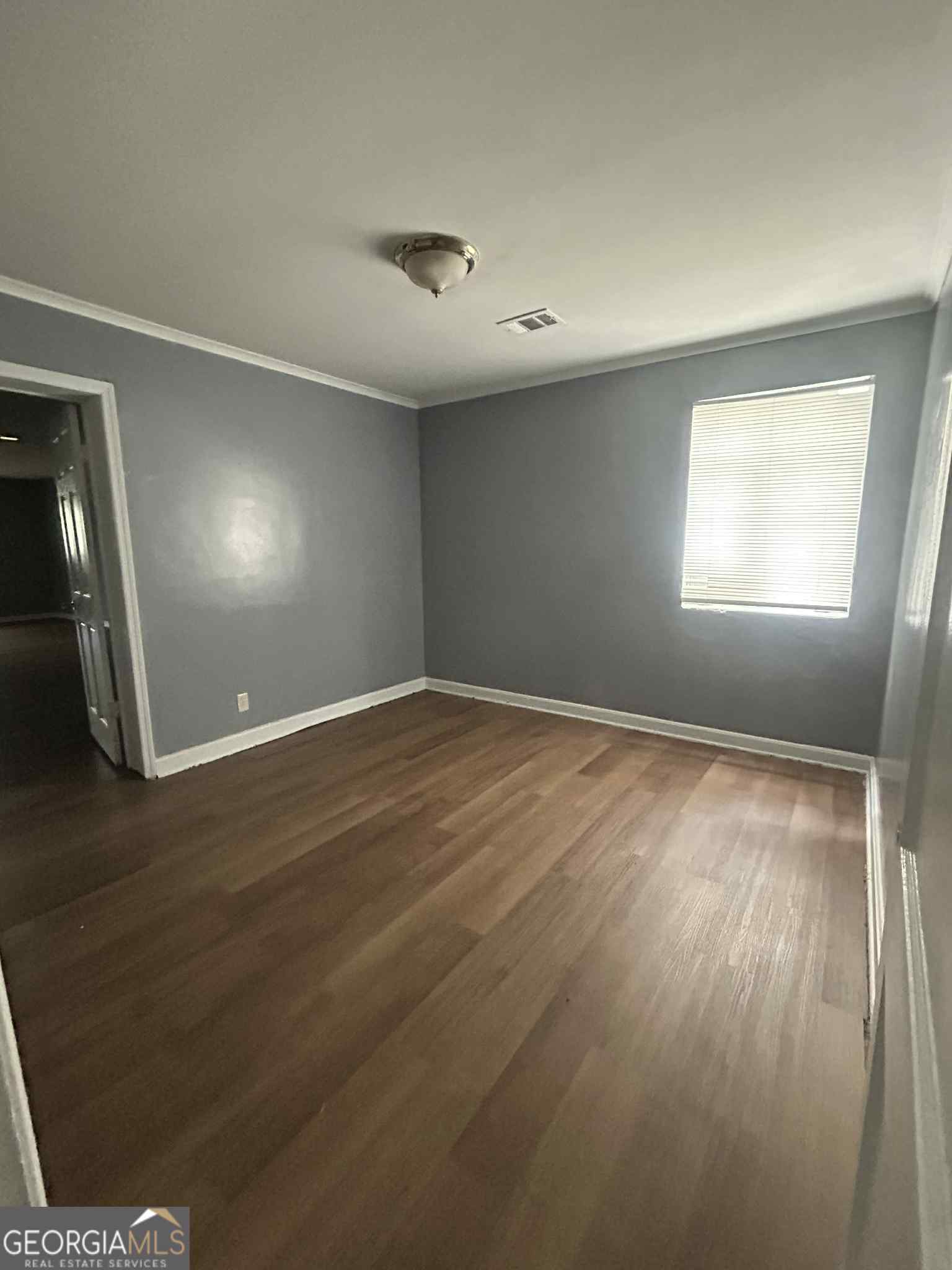 1970 Vining Circle Macon, GA 31204 - Photo 2 of 6 an empty room with wooden floor and windows
