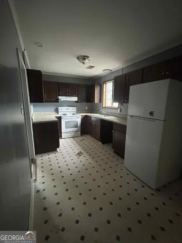 a kitchen with sink refrigerator and microwave