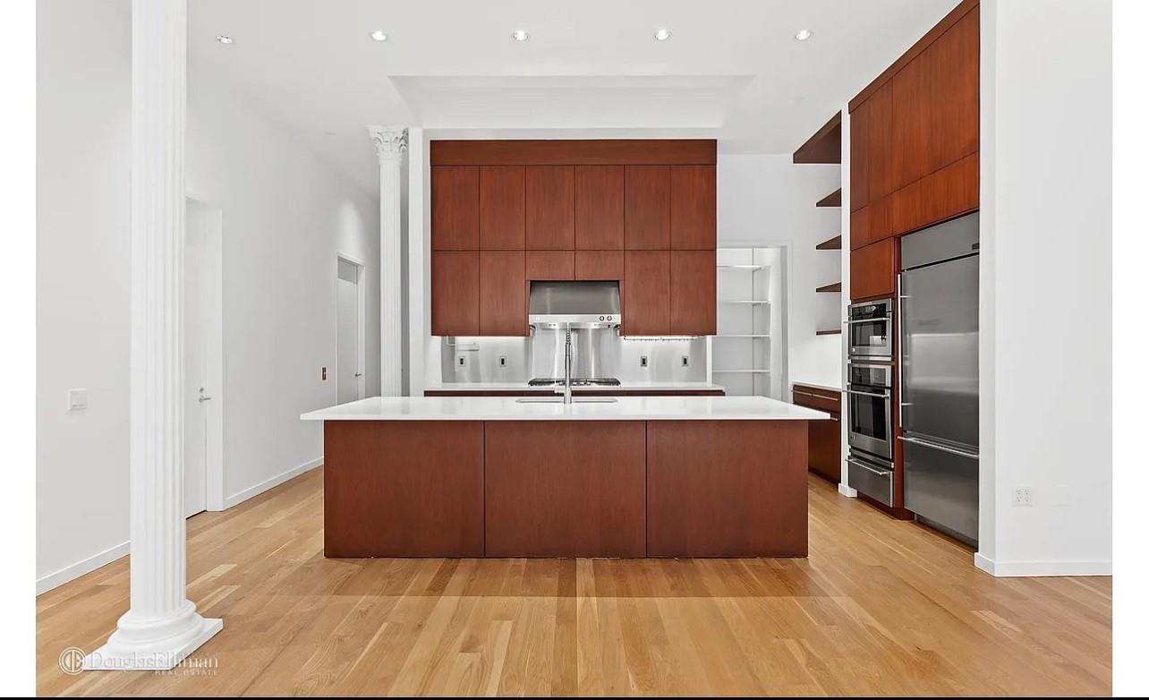 105 Franklin Street, Unit PH Manhattan, NY 10013 - Photo 1 of 4 a room with wooden cabinets and stainless steel appliances