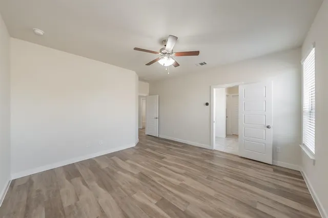 a view of a room with an empty space and a ceiling fan