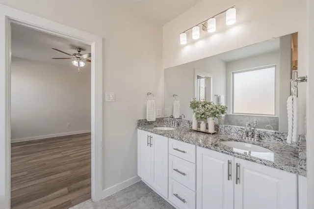 a bathroom with a granite countertop sink and a mirror