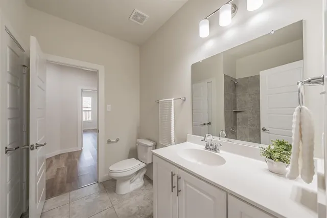 a bathroom with a granite countertop sink a toilet and a large mirror