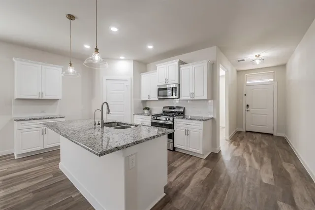 a kitchen with a refrigerator a sink and cabinets