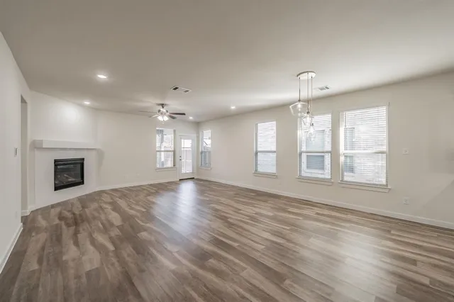 an empty room with wooden floor and fireplace