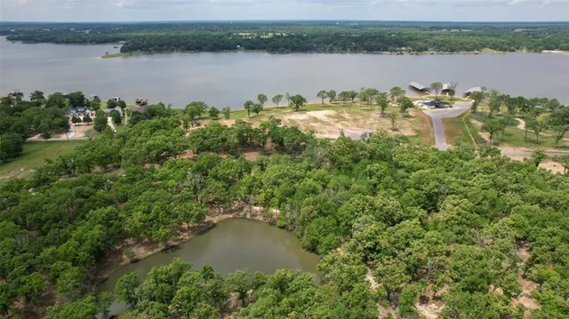 an aerial view of lake residential house with outdoor space and trees around