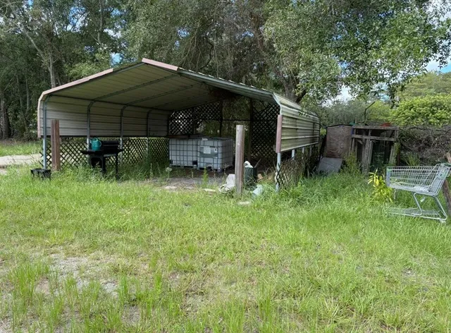 a view of backyard with table and chairs under an umbrella