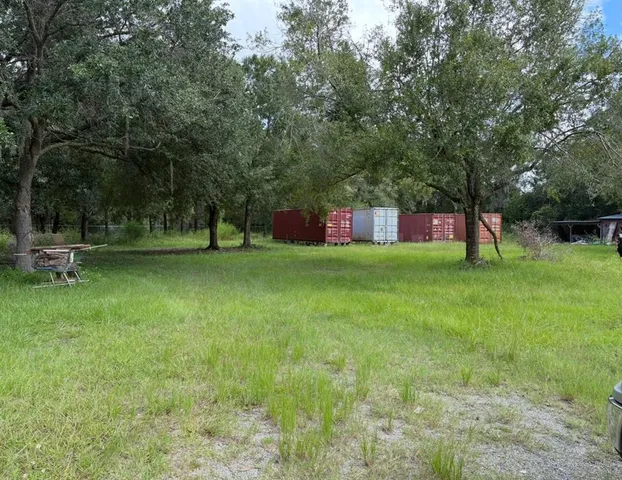 a view of pool with grass and trees
