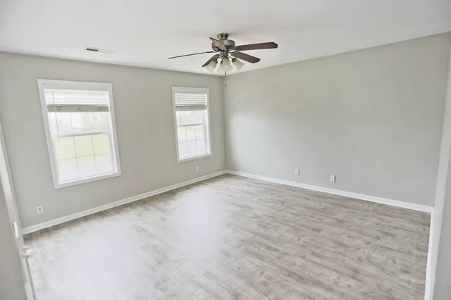 wooden floor in an empty room with a window
