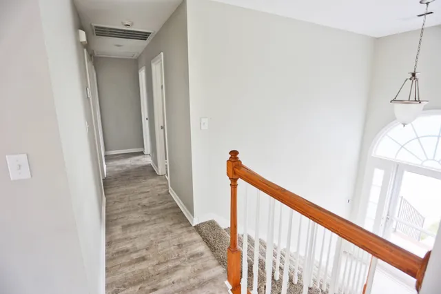 a view of a hallway with wooden floor and staircase