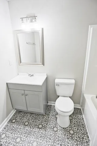 a bathroom with a toilet sink and mirror