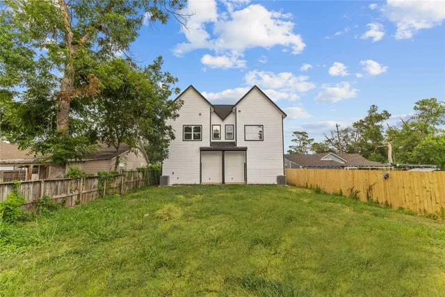 a view of a house with a big yard and a large tree