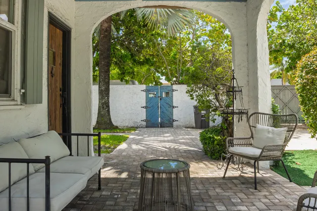 a kitchen with stainless steel appliances a stove a kitchen island a stove a sink dishwasher a dining table and chairs with wooden floor