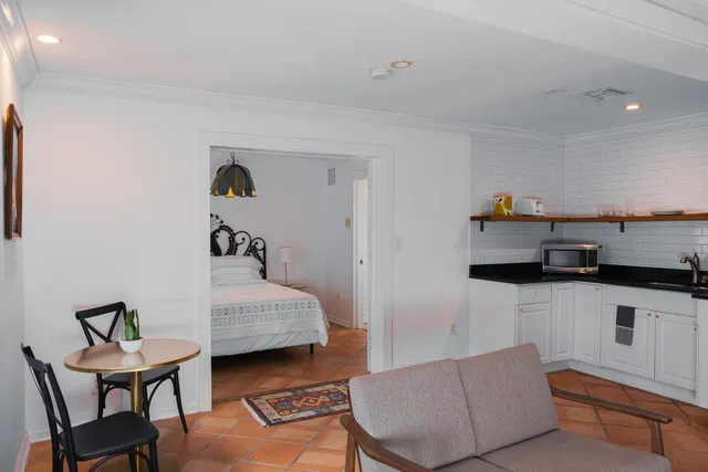 a view of a white house with a big yard and palm trees