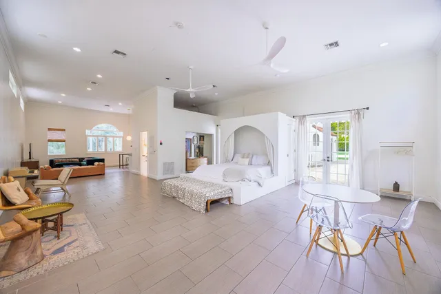 a bedroom with furniture and a large window