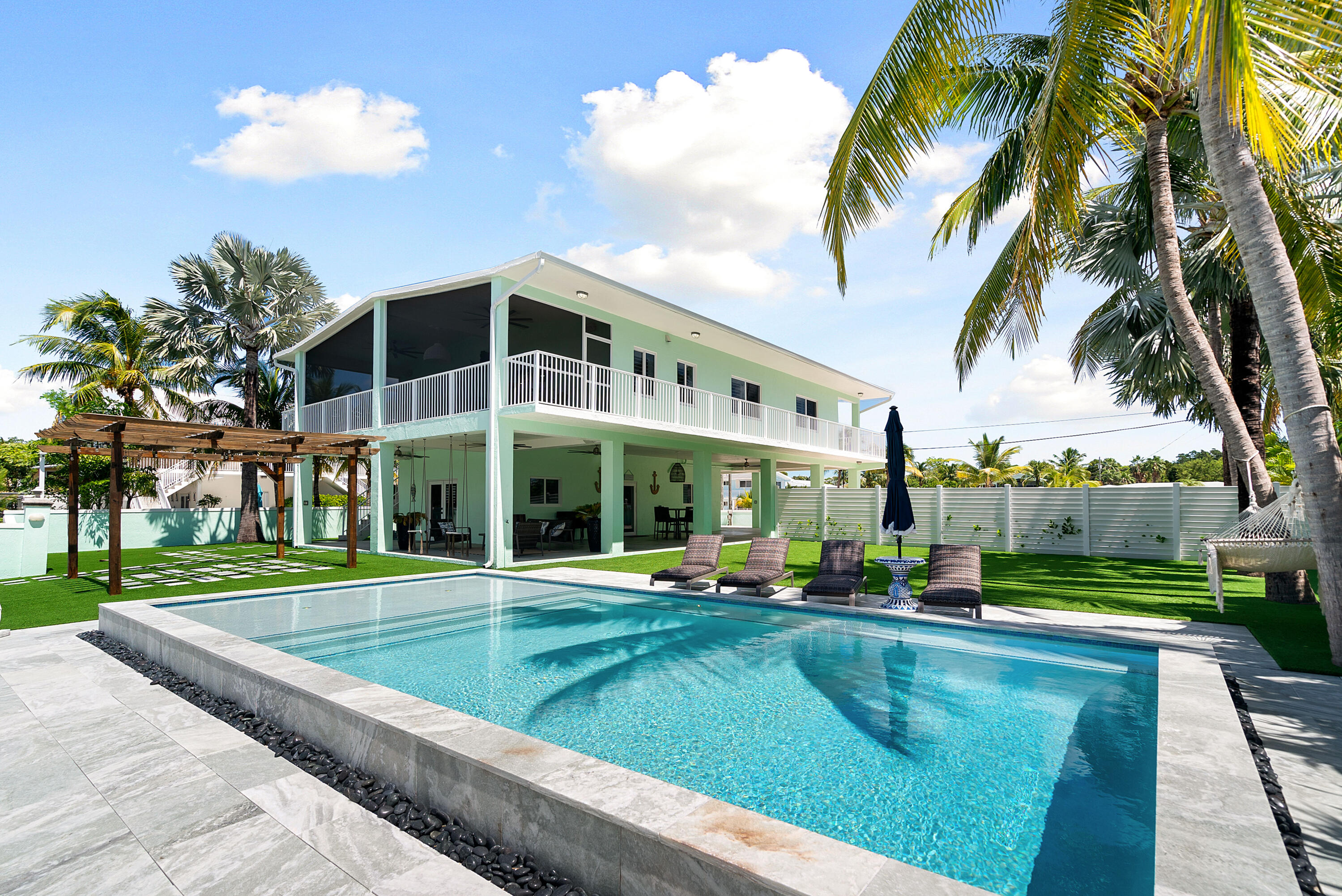 889 Ellen Drive Key Largo, FL 33037 - Photo 4 of 57 a view of a swimming pool with a garden and plants