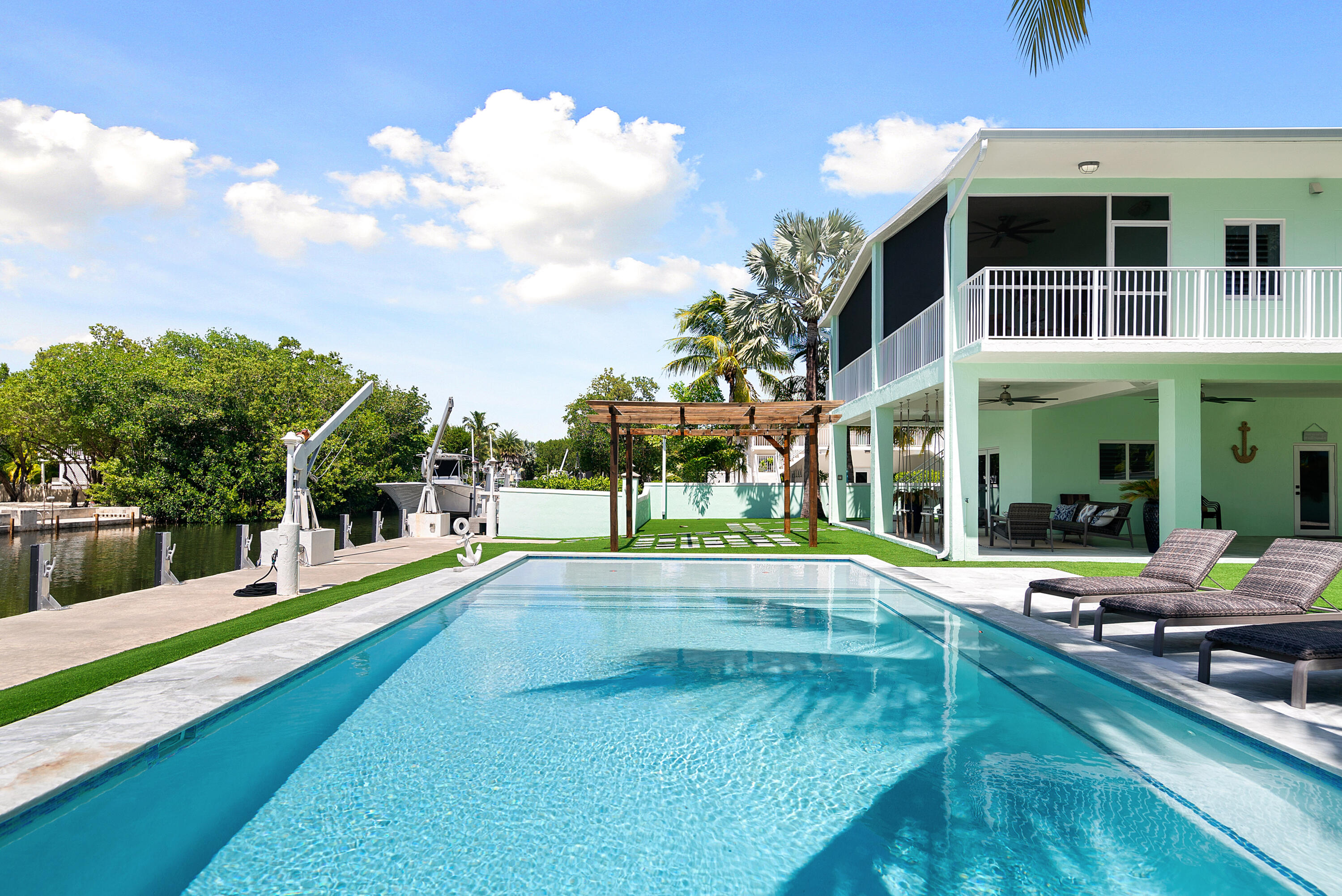 889 Ellen Drive Key Largo, FL 33037 - Photo 49 of 57 a view of a swimming pool with a bench in front of building